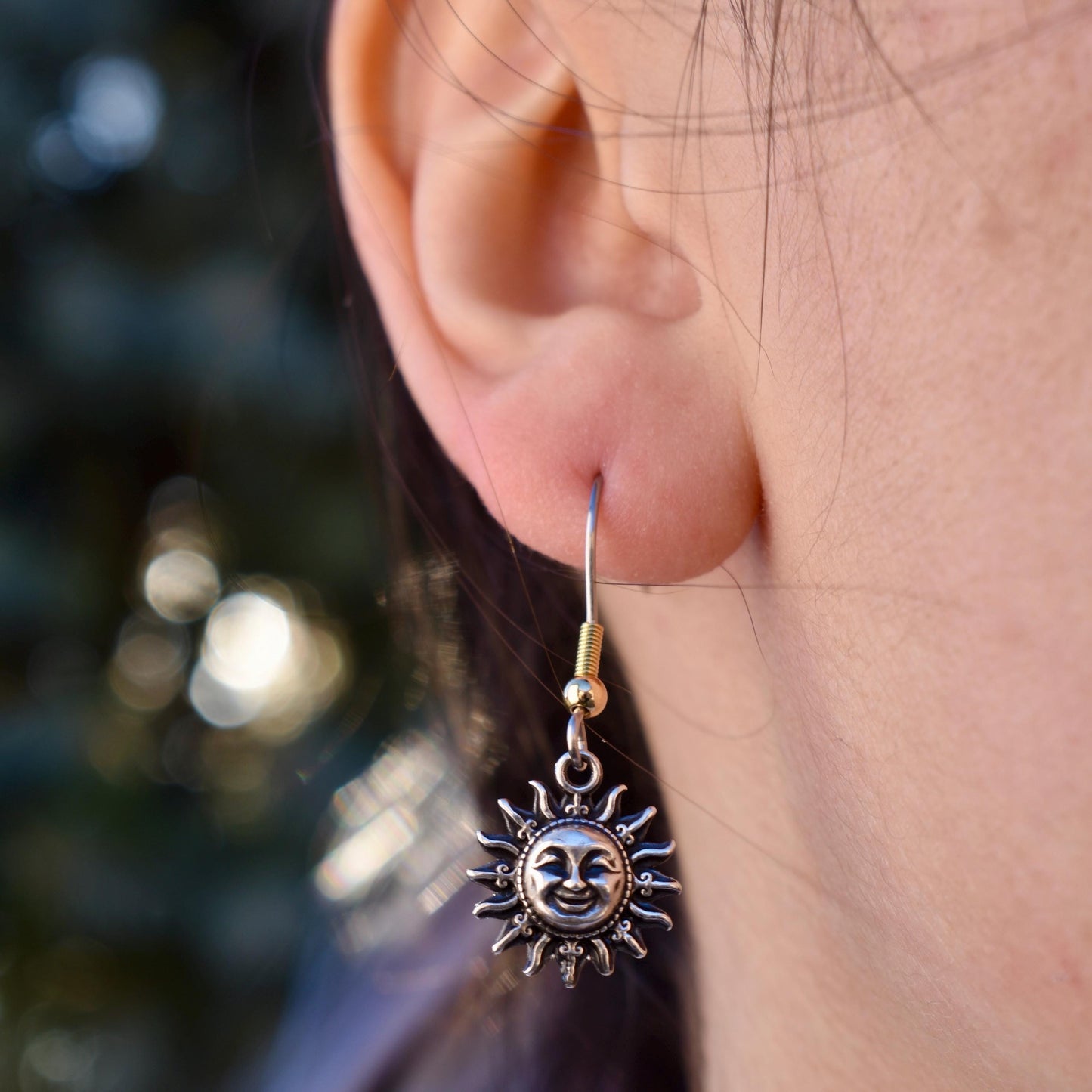 A Woman Wearing A smiling Sun Charm as Earrings - Handcrafted .925 Sterling Silver Pendant for Bracelets and earrings by The Colorado Charm Company