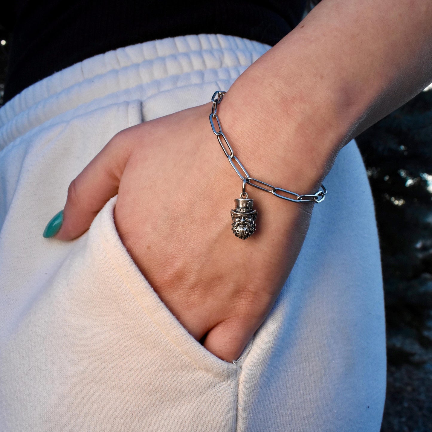 A Woman Wearing A smiling Irish leprechaun Charm On a Bracelet  - Handcrafted .925 Sterling Silver Pendant for Bracelets and earrings by The Colorado Charm Company - Front view