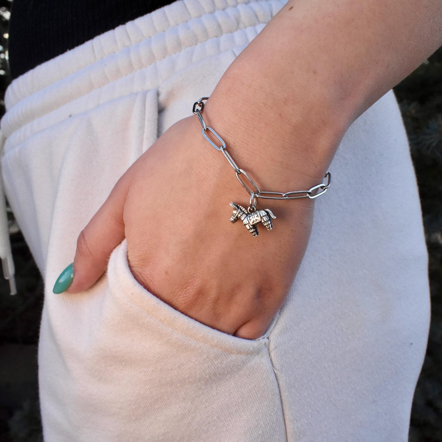 A woman wearing a donkey pinata Charm on a bracelet - Handcrafted .925 Sterling Silver Pendant for Bracelets and earrings by The Colorado Charm Company