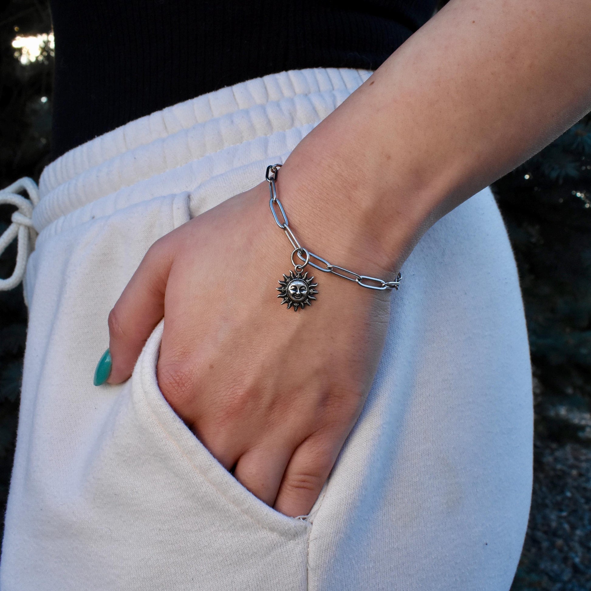 A Woman Wearing A smiling Sun Charm On a Bracelet  - Handcrafted .925 Sterling Silver Pendant for Bracelets and earrings by The Colorado Charm Company