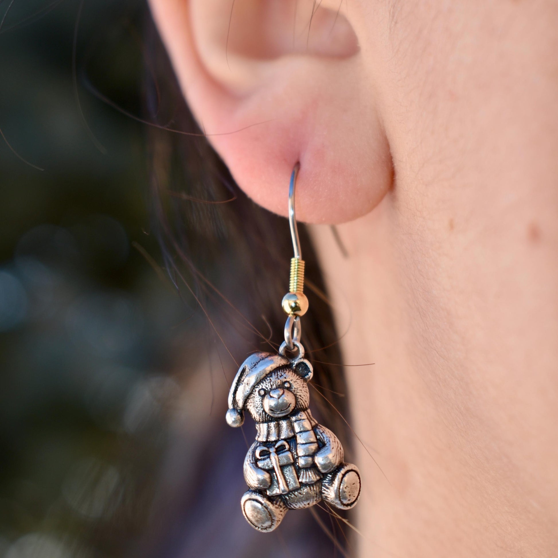 A Woman Wearing A Christmas teddy bear Charm as Earrings - Handcrafted .925 Sterling Silver Pendant for Bracelets and earrings by The Colorado Charm Company