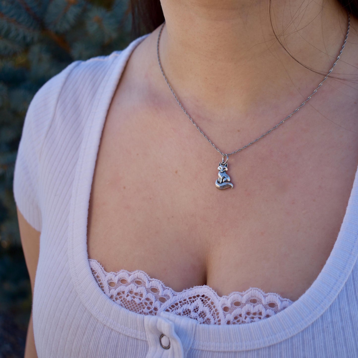 a woman wearing a resting fox Charm on a necklace - Handcrafted .925 Sterling Silver Pendant for Bracelets and earrings by The Colorado Charm Company