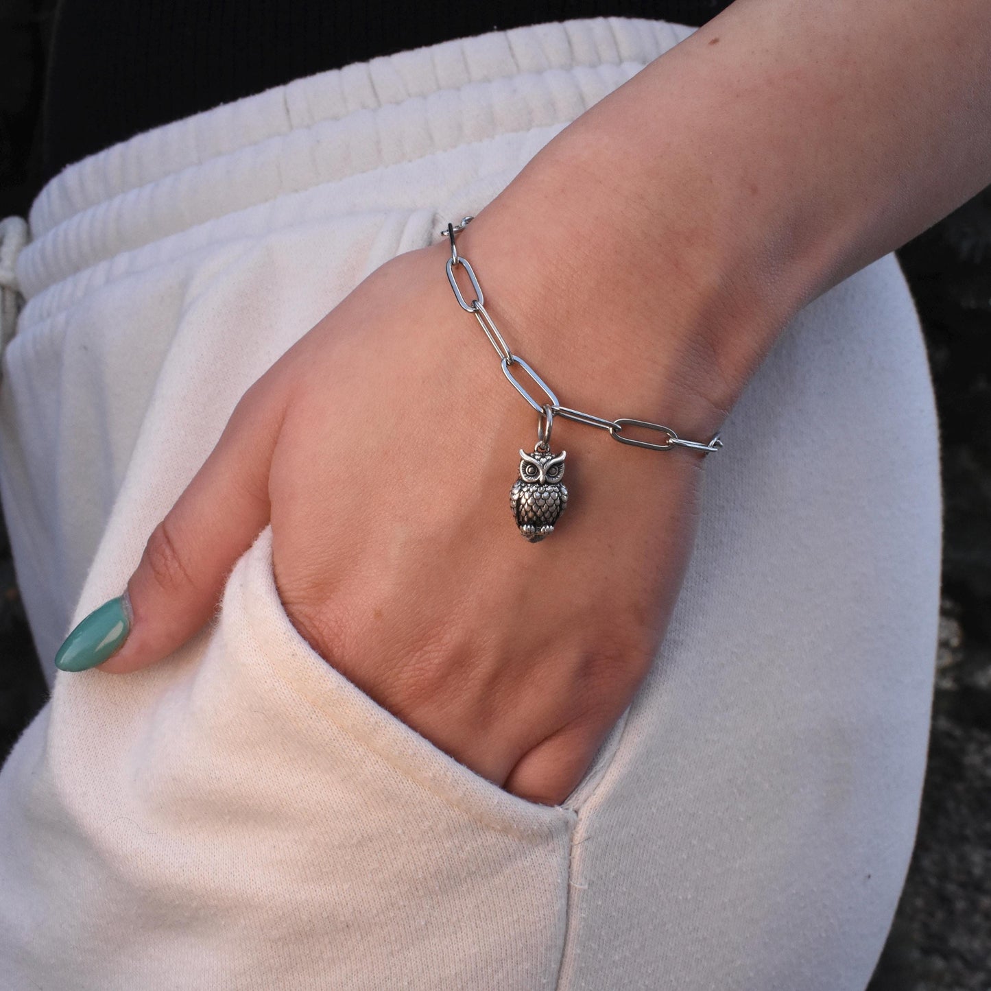 A Woman Wearing a Great Horned Owl Charm - Handcrafted .925 Sterling Silver Pendant for Bracelets and earrings by The Colorado Charm Company - Front view